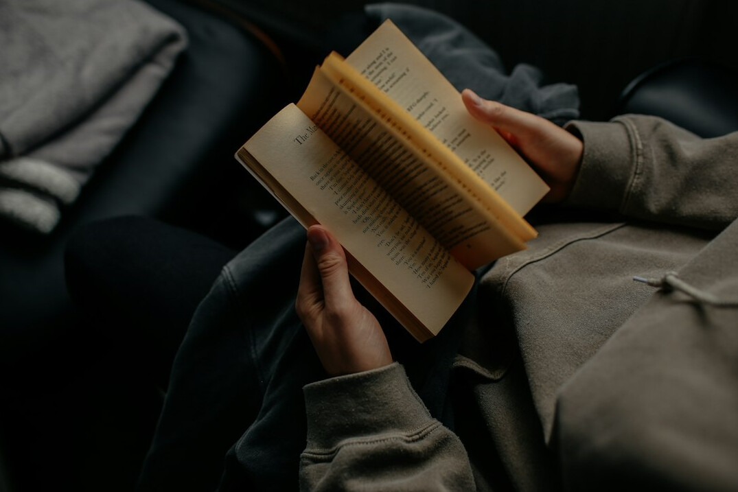 woman reading book at night